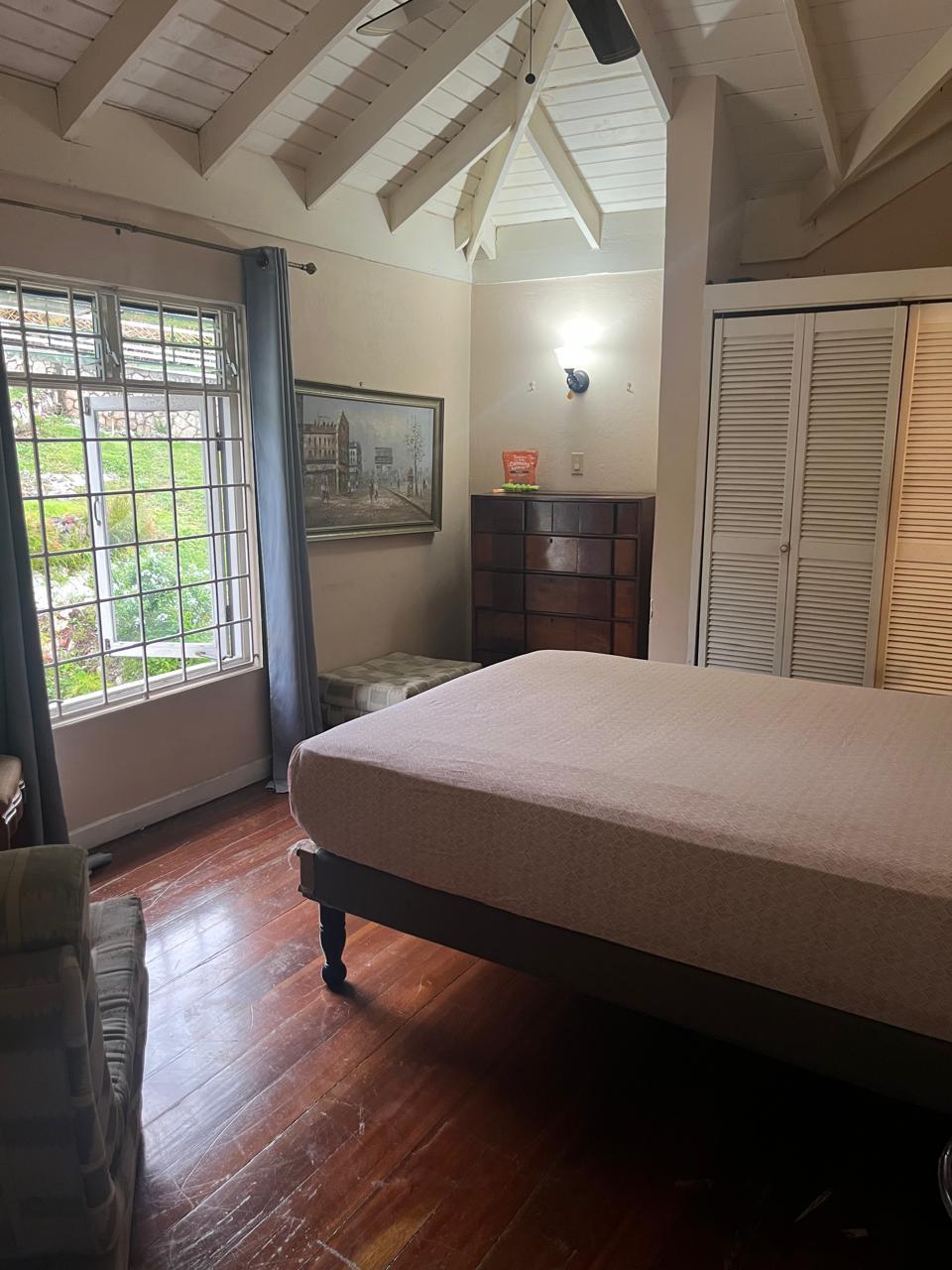 The same bedroom fully made up with crisp linens, tidy dresser and polished hardwood floors after Luxe Clean JA