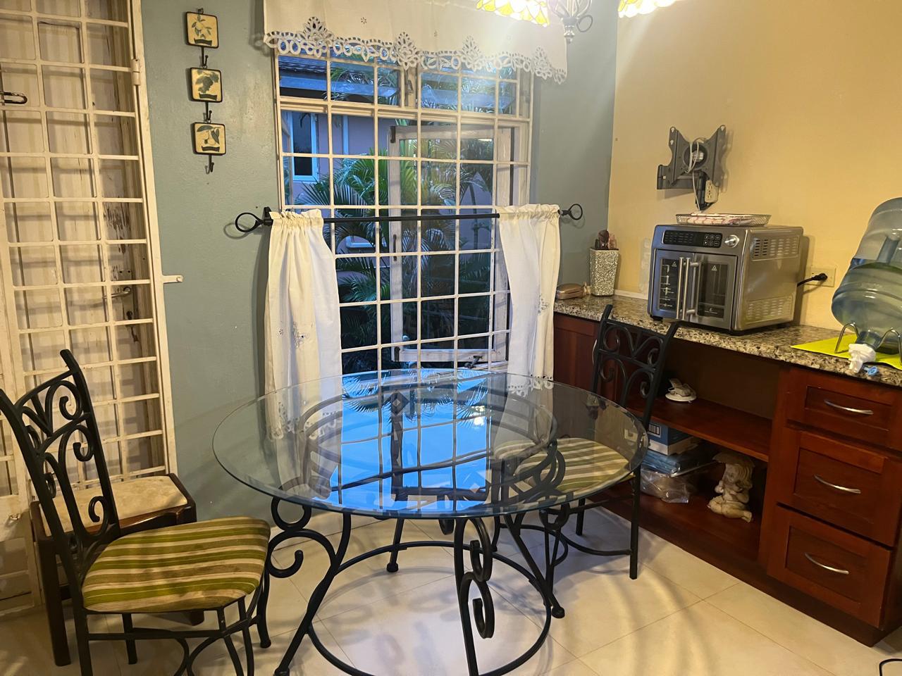 The same dining area fully cleared, dusted and shining with a spotless glass table after Luxe Clean JA